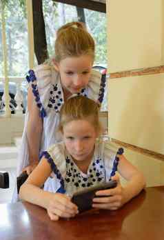 双胞胎高加索人女孩年智能手机