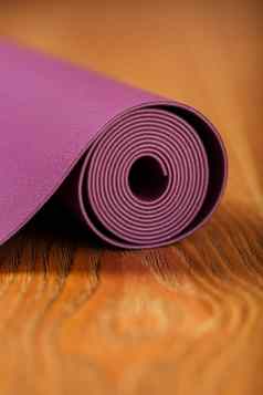 lilac-colored瑜伽席传播卷木地板上