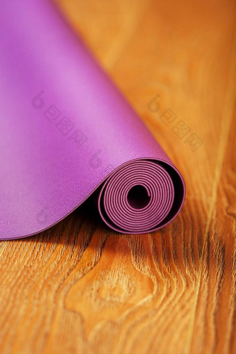 紫色的瑜伽健身席木地板上