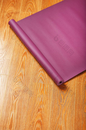 淡<strong>紫色瑜伽</strong>席扭曲的木地板上