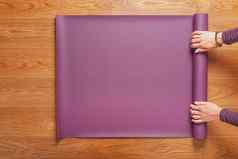 女孩了淡紫色瑜伽席锻炼实践首页木地板上