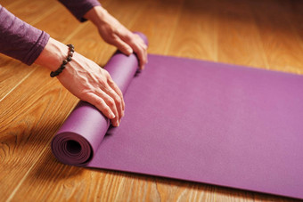 女人的手褶皱淡<strong>紫色瑜伽</strong>健身席锻炼首页生活房间