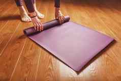 女人的手躺淡紫色瑜伽健身席锻炼实践首页木地板上