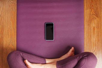 女孩练习瑜伽冥想首页淡紫色地毯智能手机移动应用程序