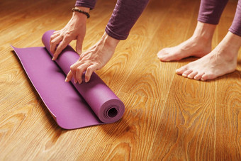 女人的手褶皱淡紫色瑜伽健身席锻炼首页生活房间