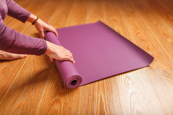 女人的手褶皱淡紫色瑜伽健身席锻炼首页生活房间