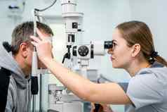 眼科医生病人测试视力男人。眼睛测试验光师眼科医生装置眼睛检查诊所医生检查病人视力测量