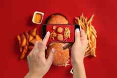 年轻的女人采取照片食物智能手机拍摄餐移动相机