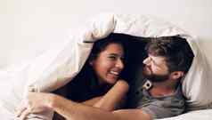 使房间放松拍摄快乐年轻的夫妇覆盖毯子床上首页