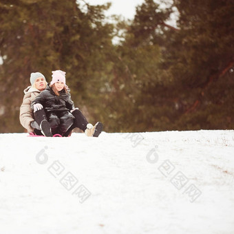 快乐妈妈。婴儿女孩坐着雪橇滑雪橇雪山享受白色冬天一天公园支出时间周末