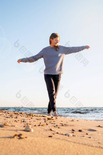 年轻的运动型女人享受日出海滩走沙子