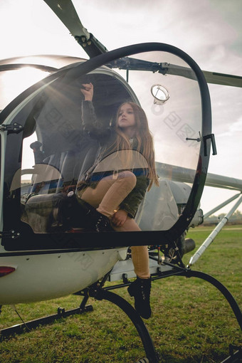13岁以下的女孩坐着开放驾驶舱<strong>降落</strong>直升机