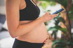 怀孕斜滑块支持健康的生活方式概念快乐的快乐怀孕了女人聪明的电话应用程序首页