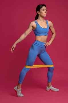 女人执行较低的身体锻炼电阻乐队栗色背景