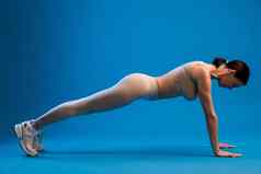 女人练习昆巴卡萨纳瑜伽构成蓝色的背景