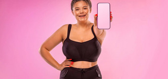 饮食<strong>健身</strong>程序<strong>模板</strong>女孩演示了屏幕智能手机演讲移动应用程序脂肪女人微笑粉红色的背景电话手