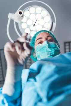 女人外科医生医疗统一的专业工具站明亮的光操作剧院