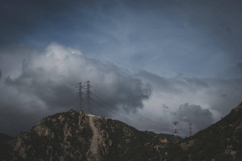 真正的自然景观背景岩石山多云的苍白的蓝色的黑暗狂风暴雨的天空秋天一天高电压电权力塔冷情绪感情问题困难障碍不舒服