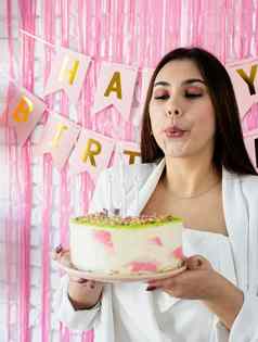 美丽的女人庆祝生日聚会，派对持有蛋糕吹蜡烛