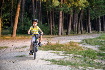 肖像快乐活跃的十几岁的男孩安全头盔放松学校骑自行车美丽的公园阳光明媚的秋天一天