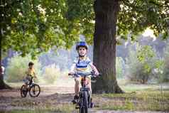 孩子男孩色彩斑斓的休闲衣服夏天森林公园开车自行车活跃的孩子们骑自行车阳光明媚的秋天一天自然安全体育休闲孩子们概念