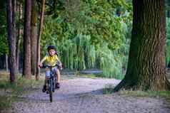 肖像快乐蹒跚学步的孩子男孩骑自行车头盔游乐设施小山桑迪森林路径体育运动概念孩子们骑自行车自行车活跃的蹒跚学步的孩子