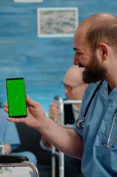 男人。护士持有绿色屏幕智能手机