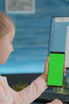 孩子垂直持有智能手机绿色屏幕