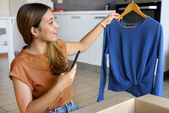 检查产品交付客户时尚的小业务老板女人智能手机应用程序出售服装在线小业务企业家
