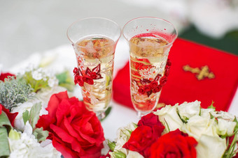 香槟眼镜婚礼仪式在户外花束红色的花