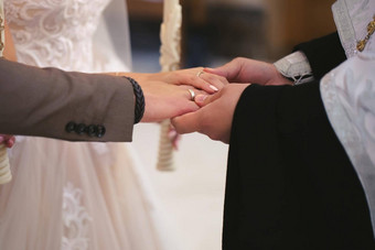 牧师奉献婚礼环手指新娘新郎婚礼传统仪式手年轻的夫妇教堂