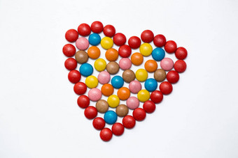 色彩斑斓的按钮巧克力糖果爱形状白色背景