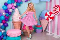肖像快乐的年轻的女人粉红色的衣服背景装饰巨大的糖果冰奶油