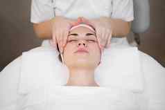 美容师使专业按摩脸脖子肩膀年轻的女孩水疗中心沙龙视图前面部美治疗
