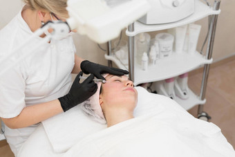 美容师使注射女人的脸特写镜头biorevitalization过程注射美容特写镜头手手套持有注射器视图前