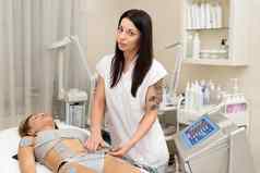专业美容师使瘦身按摩年轻的女人biostimulating装置女人美医疗水疗中心中心瘦身电刺激治疗