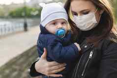 美丽的女人儿子穿保护面具电晕病毒科维德病毒爆发城市