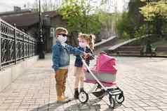 男孩女孩走婴儿车保护脸面具概念家庭冠状病毒科维德