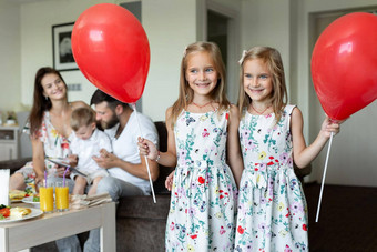 双胞胎姐妹构成气球背景家庭吃早餐酒店房间