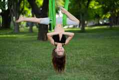 女孩瑜伽练习吊床公园