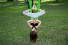 女孩瑜伽练习吊床公园