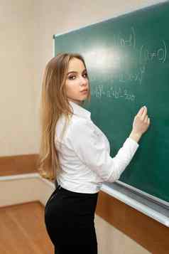 年轻的学生女孩需要考试黑板上