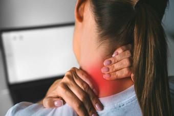 脖子疼痛工作电脑年轻的女人按摩脖子缓解疼痛工作