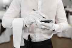 服务员白色衬衫弓领带写作订单咖啡馆关闭