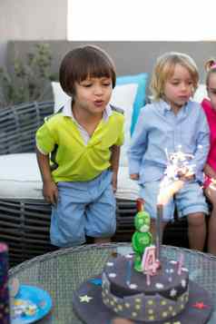 孩子们生日聚会，派对孩子吹蜡烛色彩斑斓的蛋糕