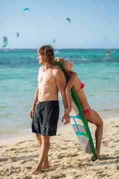 年轻的夫妇海滩冲浪板手臂冲浪户外体育运动生活方式概念