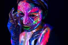 时尚模型女人霓虹灯光肖像美丽的模型女孩荧光化妆身体艺术设计女迪斯科舞者摆姿势画脸色彩斑斓的使黑色的背景