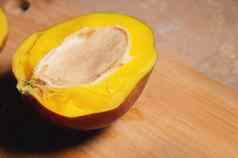 减少成熟的芒果一半切割董事会首页厨房黄色的多汁的美味的芒果甜蜜的热带水果素食者饮食健康的吃视图