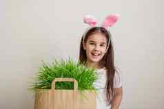 可爱的女孩粉红色的兔子耳朵站纸袋草