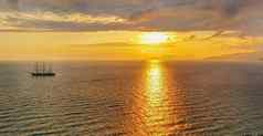 浪漫的金日落海游艇背景山橙色云平静场景温暖的和平晚上
